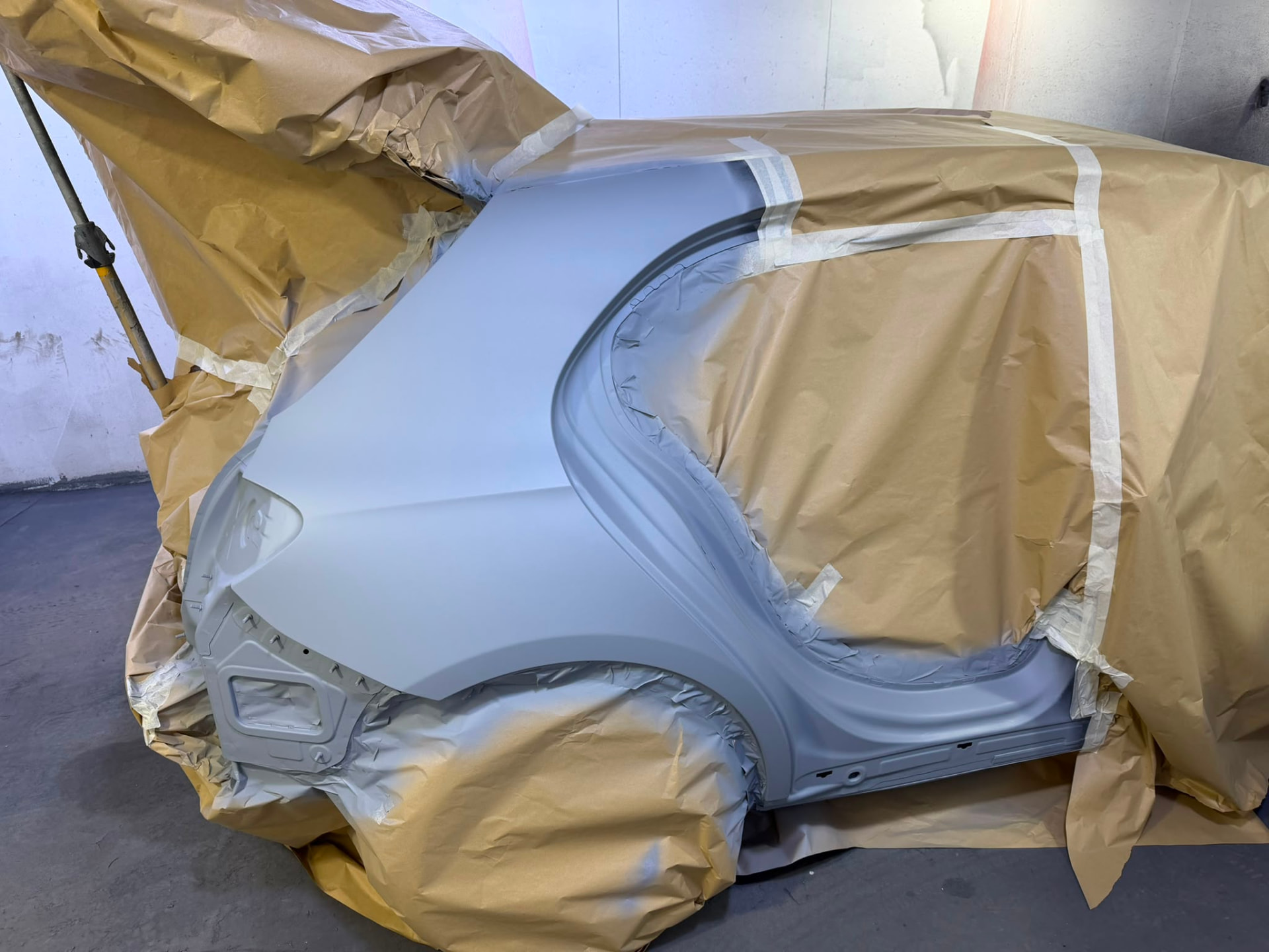 Masked and primed rear quarter panel in the spray booth